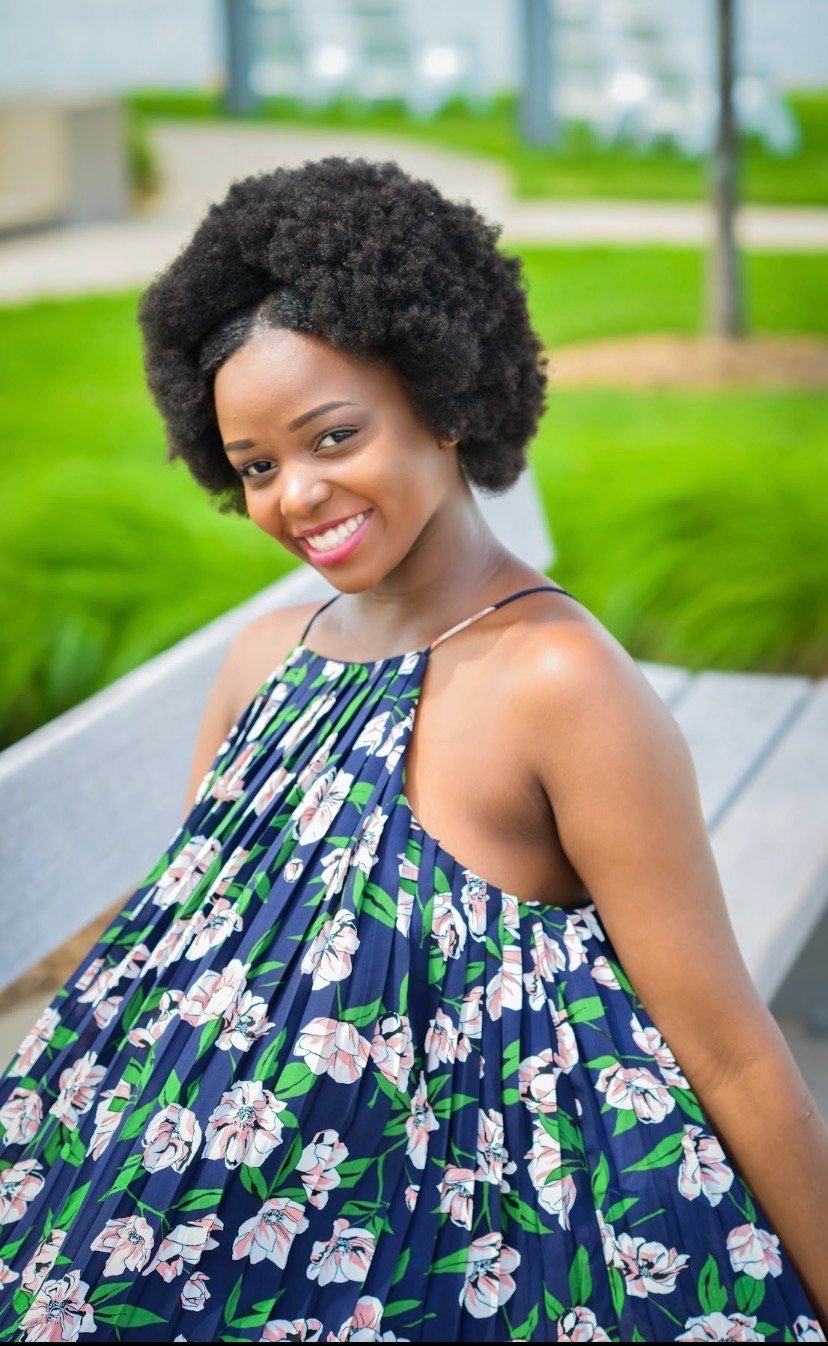 Esther Onami, smiling, in a navy floral dress
